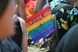 queer and proud sign on rainbow