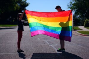 2 people holding rainbow flag