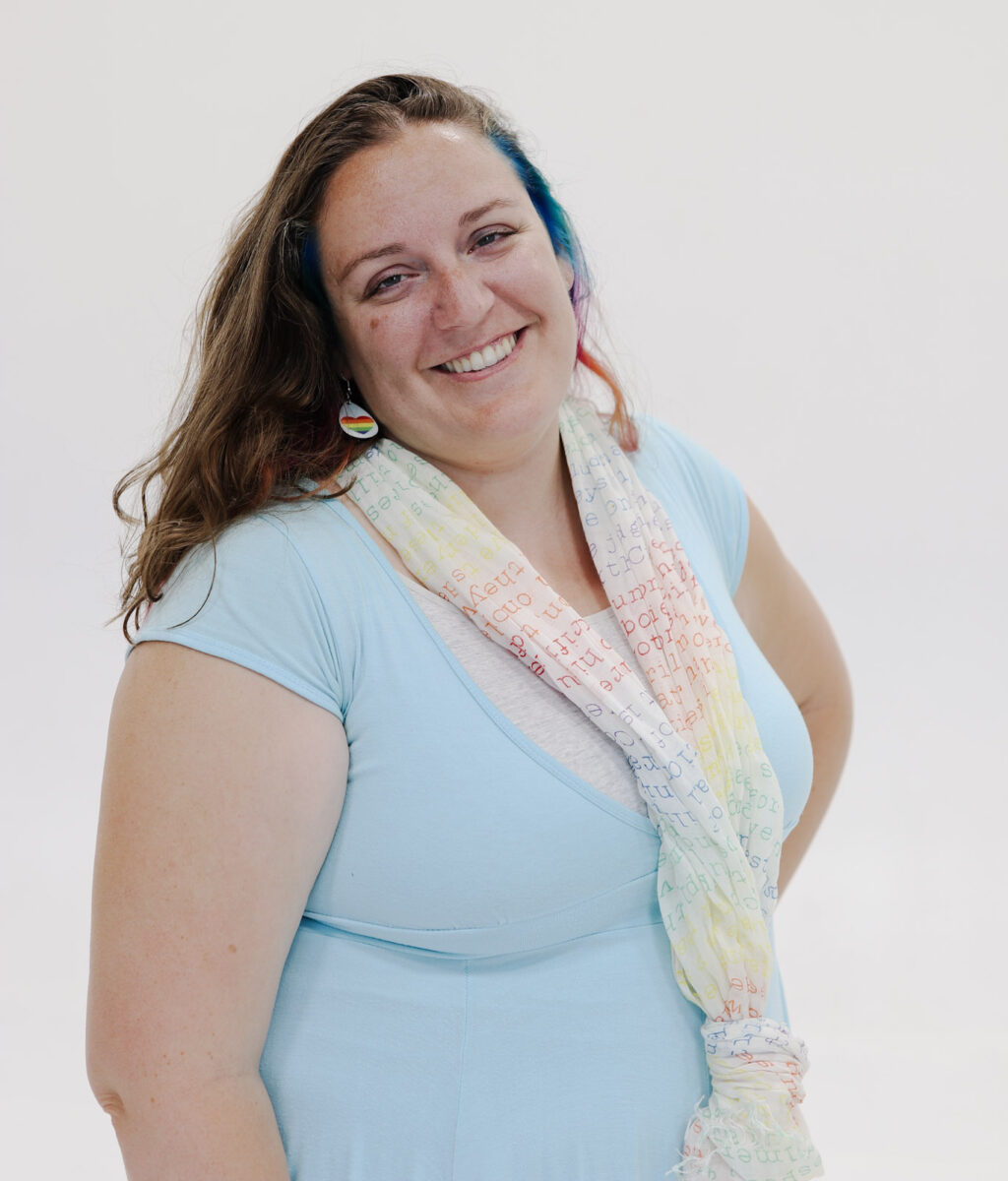 Colette Dalton in a blue dress and rainbow scarf
